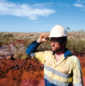 Man with hard hat standing in outback